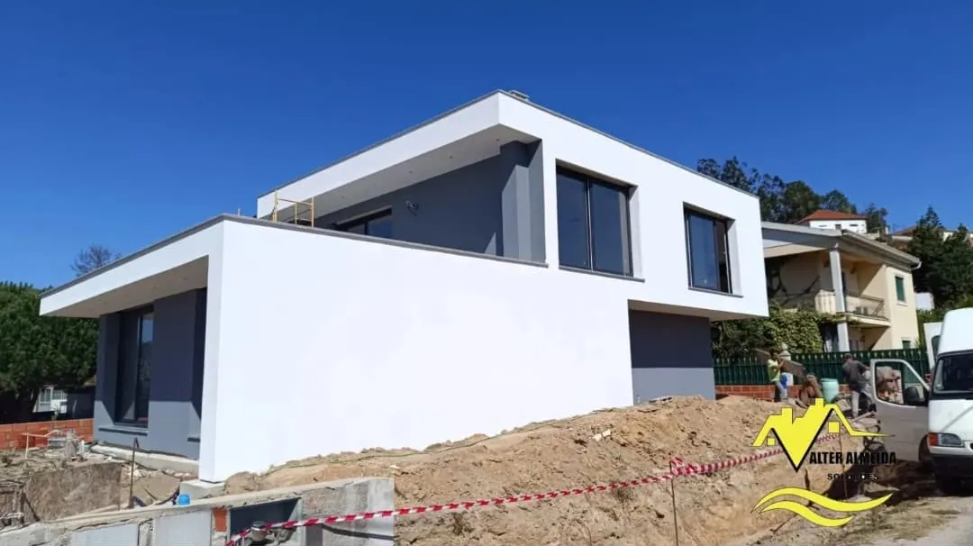 Moradia contemporânea com fachada pintada em branco e cinza